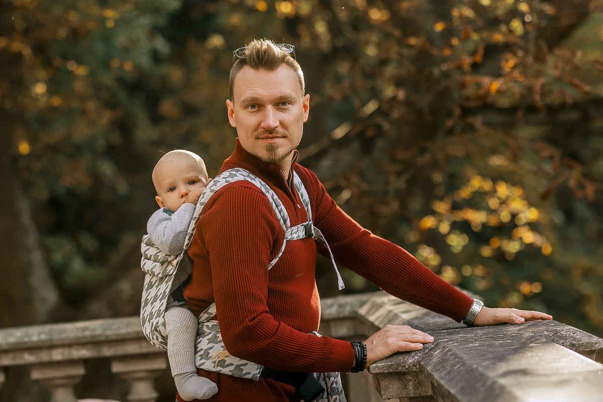 Vater mit Kind auf dem Rücken an der Balustrade im Park.