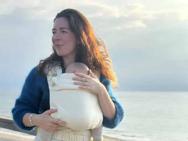 Krystyna Cordes stands on the coast, the wind in her hair, wearing a MonDoudou in natural white.